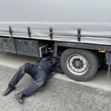 Das Bild zeigt eine Kontrolle eines Lkw durch einen Polizeibeamten.