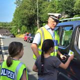 Kinder geben Dankzettel mit Polizist