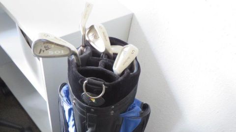 Das Bild zeigt eine blaue Golftasche mit Schlägern.
