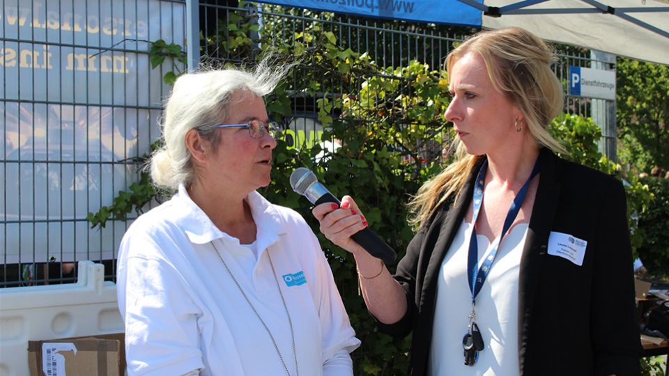 zwei Damen im Gespräch, rechte Dame hält ein Mikro in der Hand