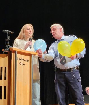 Frau und Mann halten Ballons mit aufgeschriebenen Träumen