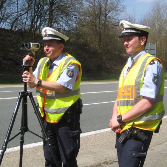 Das Bild zeigt Polizeibeamte bei einer Geschwindigkeitsmessung mit dem Lasergerät.